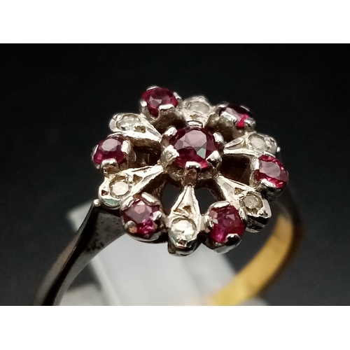 603 - An 18 K white & yellow gold ring with a cluster of rubies and diamonds.