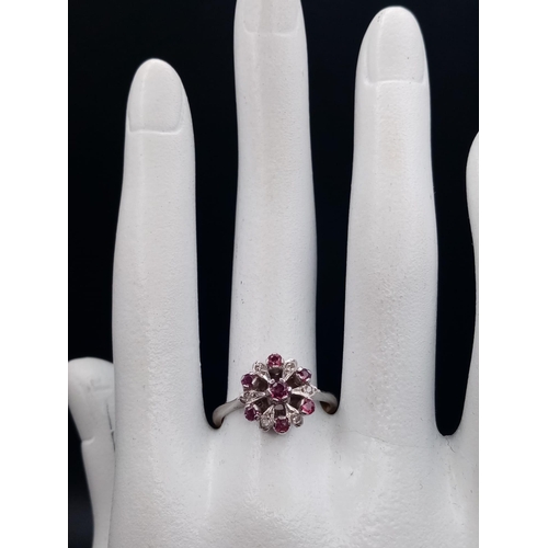 603 - An 18 K white & yellow gold ring with a cluster of rubies and diamonds.