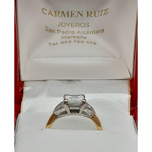 24 - An 18K Yellow Gold Diamond Solitaire Ring. Excellent quality princess cut 2ct centre stone flanked b... 