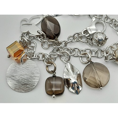 444 - A sterling silver bracelet with smoky quartz and 13 charms. Weight: 24.1 g.