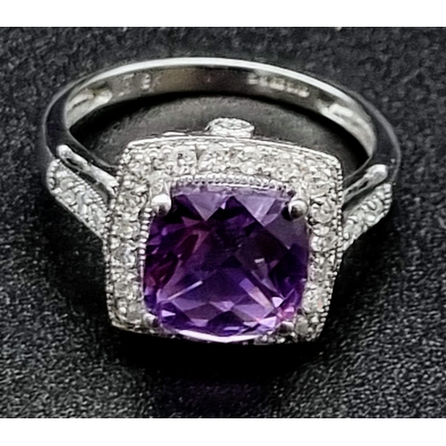 367 - An Eye-Catching 9K White Gold Amethyst and Diamond Ring. Multi-faceted central clean amethyst surrou... 