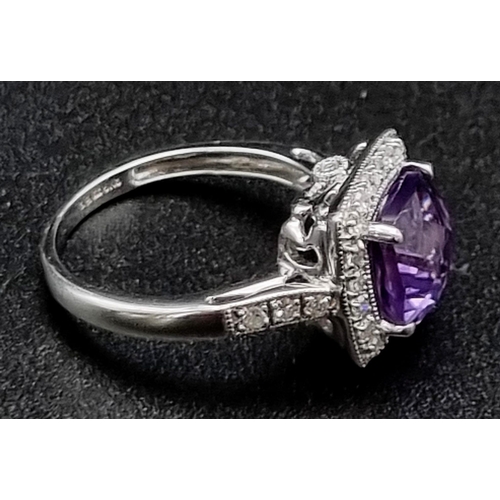 367 - An Eye-Catching 9K White Gold Amethyst and Diamond Ring. Multi-faceted central clean amethyst surrou... 