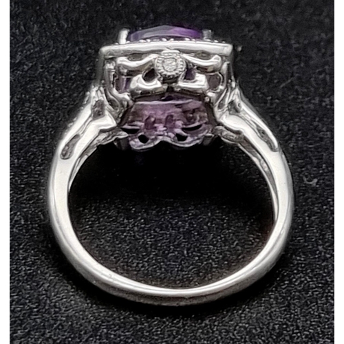 367 - An Eye-Catching 9K White Gold Amethyst and Diamond Ring. Multi-faceted central clean amethyst surrou... 