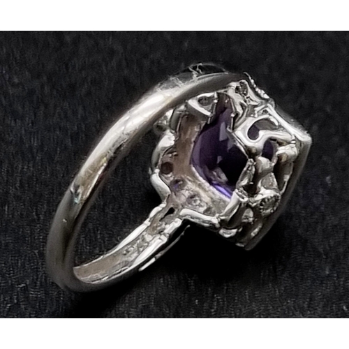 367 - An Eye-Catching 9K White Gold Amethyst and Diamond Ring. Multi-faceted central clean amethyst surrou... 