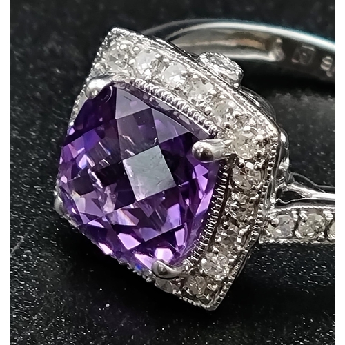 367 - An Eye-Catching 9K White Gold Amethyst and Diamond Ring. Multi-faceted central clean amethyst surrou... 