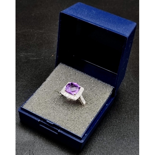 367 - An Eye-Catching 9K White Gold Amethyst and Diamond Ring. Multi-faceted central clean amethyst surrou... 