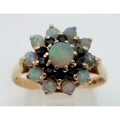 162 - A 9 K yellow gold ring with a cluster of opals and sapphires. Size: P, weight: 3.2 g.