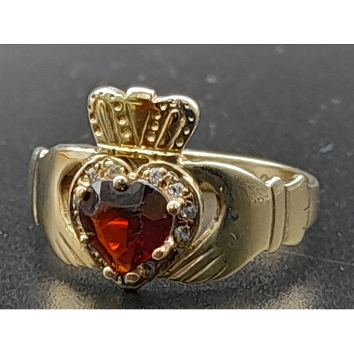 233 - A 9 K yellow gold garnet set Claddagh ring. Size: P, weight: 2.9 g.