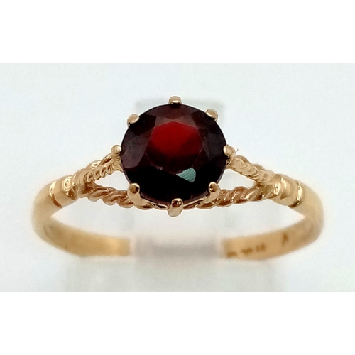 306 - A 9 K yellow gold garnet solitaire ring. Size: Q, weight: 1.5 g.