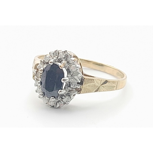 601 - A 9 K yellow gold ring with an oval cut sapphire surrounded by a halo of diamonds. Size: K, weight: ... 