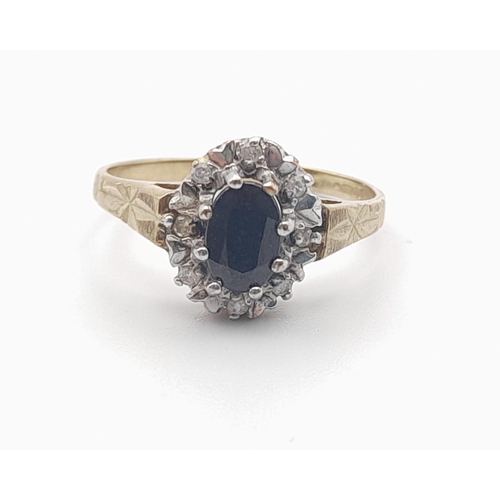 601 - A 9 K yellow gold ring with an oval cut sapphire surrounded by a halo of diamonds. Size: K, weight: ... 