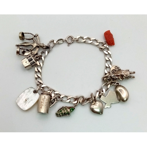 608 - A sterling silver bracelet with eleven charms. Weight: 28.7 g.