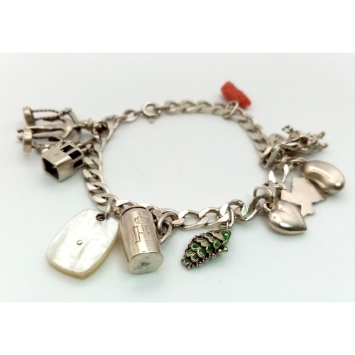 608 - A sterling silver bracelet with eleven charms. Weight: 28.7 g.