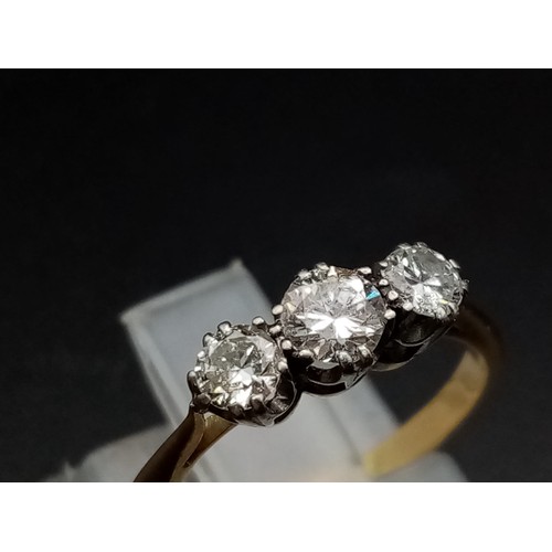 206 - A three stone diamond ring made up of 0.65 carat diamonds set in 18ct yellow gold with a platinum he... 