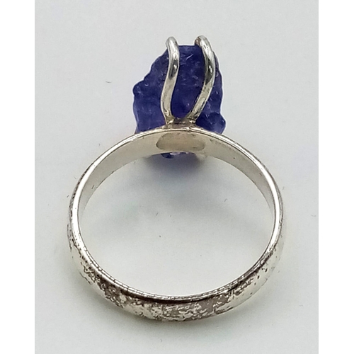 231 - A sterling silver ring with a large, natural, rough, Tanzanite, in a red rose shaped presentation bo... 