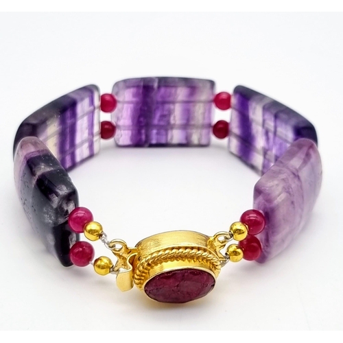 245 - A vintage mauve striped fluorite and ruby bracelet with a complimenting ruby clasp, in a presentatio... 