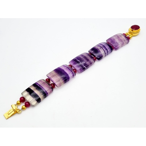 245 - A vintage mauve striped fluorite and ruby bracelet with a complimenting ruby clasp, in a presentatio... 