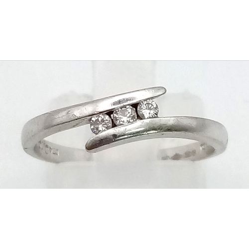 156 - A PLATINUM 3 DIAMOND CROSSOVER RING.  2.9gms   size N