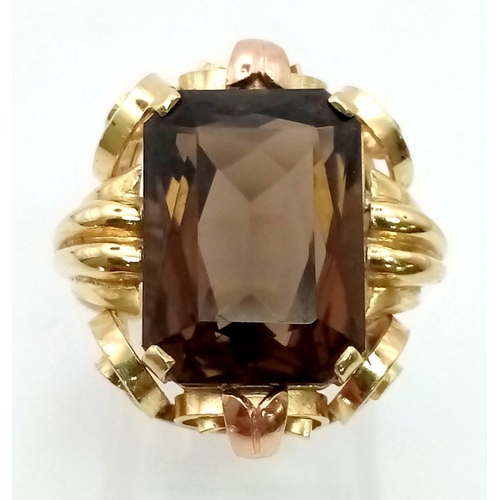 201 - A 1940s 14K Yellow Gold Smokey Quartz Cocktail Ring. A large emerald cut topaz housed in a scrolled ... 