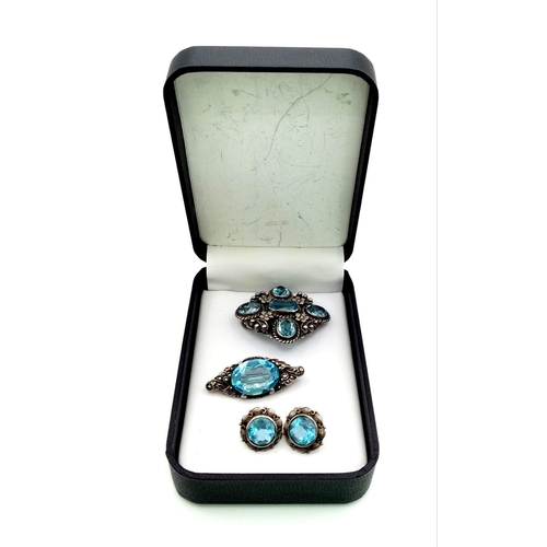 208 - A Hypnotising Blue Gemstone Jewellery Suite. Comprising of earrings and two brooches set in silver. ... 