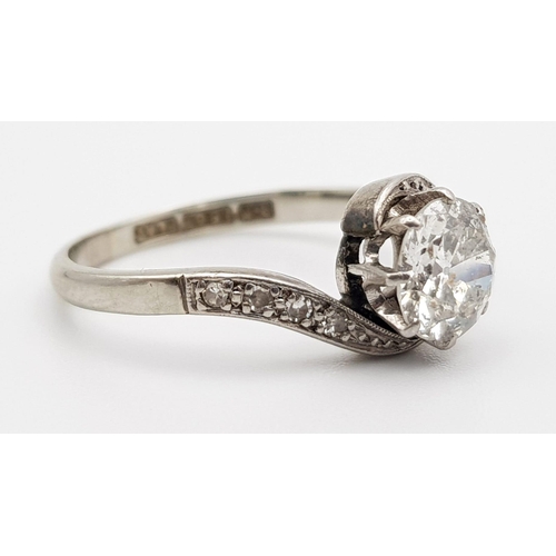 11 - A Beautiful 18K White Gold and Platinum Diamond Crossover Ring. A clean brilliant round cut 1ct cent... 