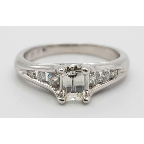 37 - An 18K White Gold Emerald Cut Diamond Ring. 0.5ct central diamond with three graduated round cut dia... 