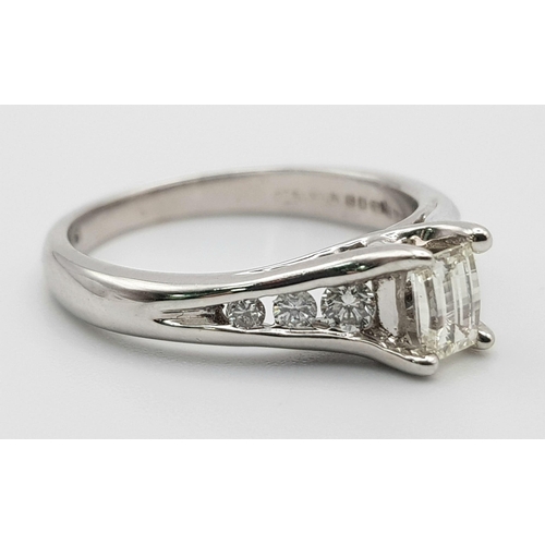 37 - An 18K White Gold Emerald Cut Diamond Ring. 0.5ct central diamond with three graduated round cut dia... 