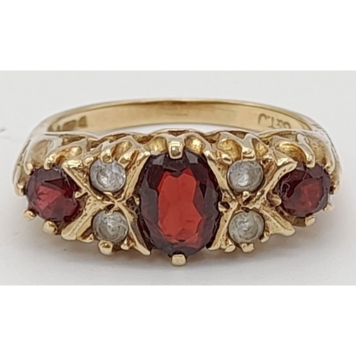 501 - A 9K Yellow Gold Garnet and White Stone Ring. Size O1/2. 3.55g total weight.