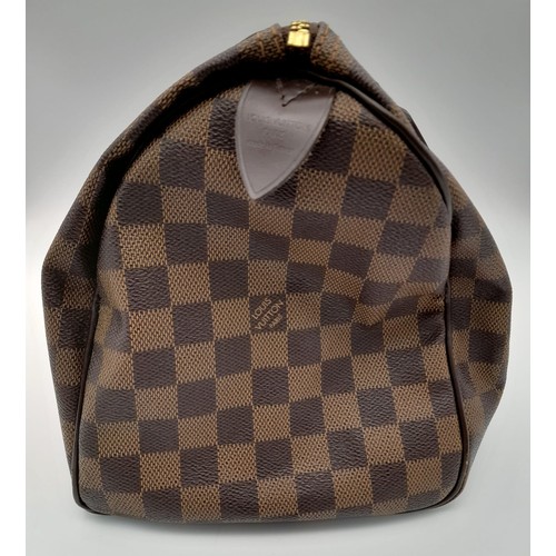 32 - A Louis Vuitton Speedy Checked Canvas Bag. Leather handles. Padlock. Red interior with flap pocket. ... 