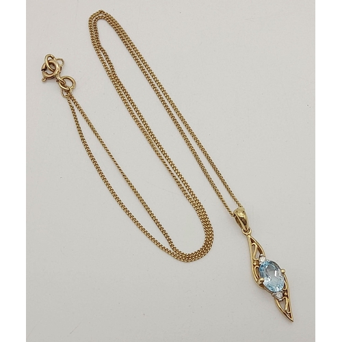 477 - A 9K Yellow Gold Topaz and Diamond Pendant on a 9K Gold Necklace. Blue oval cut topaz with a small d... 