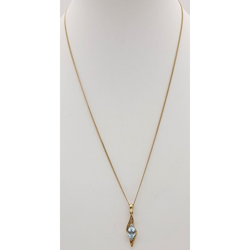 477 - A 9K Yellow Gold Topaz and Diamond Pendant on a 9K Gold Necklace. Blue oval cut topaz with a small d... 