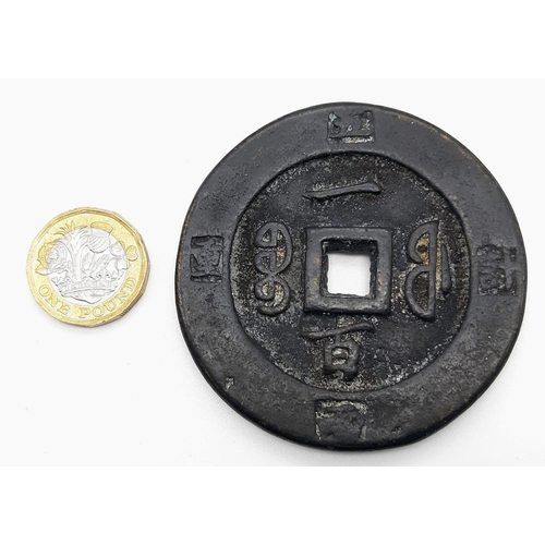 673 - A Large Antique Chinese Coin. 65mm diameter. 6.5mm thick.