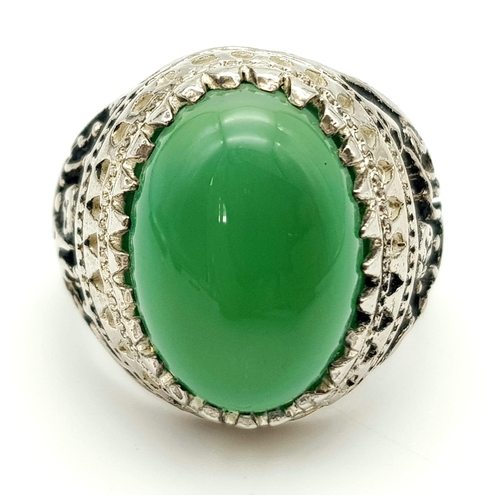 973 - A Large Green Oval Gemstone Cabochon Gents Ring. Large cabochon centre stone set in white metal - wi... 