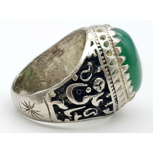 973 - A Large Green Oval Gemstone Cabochon Gents Ring. Large cabochon centre stone set in white metal - wi... 