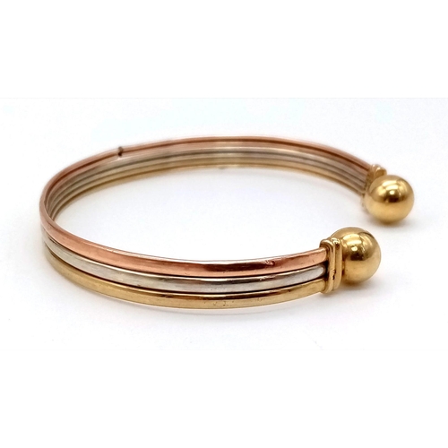 18 - An Italian 9K Three-Colour Open-Ended Bangle. 6g.