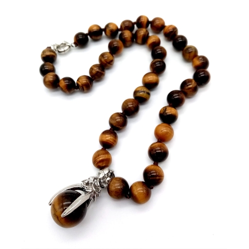 337 - A Tiger's Eye Beaded Necklace with Claw Attached Tiger's Eye Pendant. 10mm beads. 3 and 42cm.