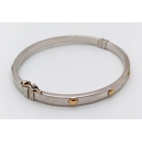 1016 - A 9K White Gold Bangle. Touches of yellow gold for decoration. Opening clasp. 6cm inner diameter. 6.... 