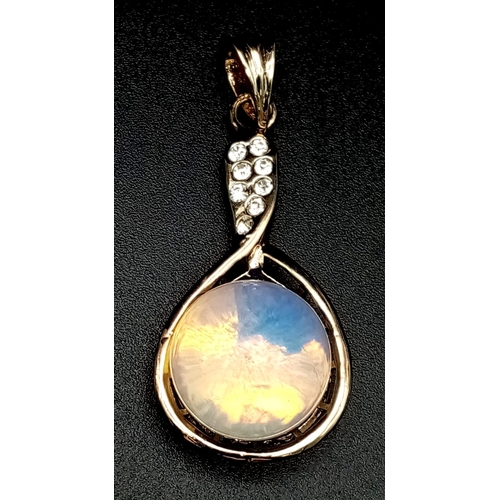 1213 - A Moonstone Ball Pendant on Gilded Metal with White Stone Decoration. 4cm