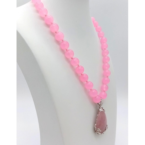 355 - A Pink Quartz Bead Necklace and Teardrop Pendant. 10mm beads.
3.5 and 42cm.