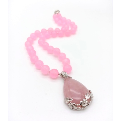 355 - A Pink Quartz Bead Necklace and Teardrop Pendant. 10mm beads.
3.5 and 42cm.