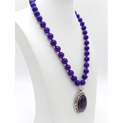 586 - An Amethyst Bead Necklace and Pendant. 10mm beads. 4 and 42cm.