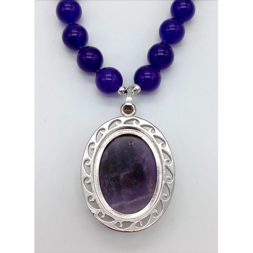 586 - An Amethyst Bead Necklace and Pendant. 10mm beads. 4 and 42cm.