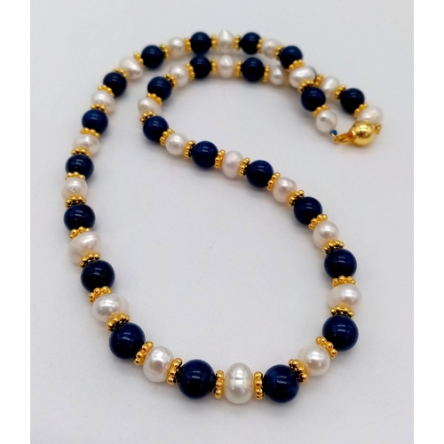 695 - A Freshwater Peral and Lapis Lazuli Necklace. Gilded spacers and clasp. 44cm