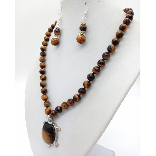 876 - A Tigers Eye Jewellery Set Comprising of: Necklace with tortoise shaped pendant. A pair of drop earr... 