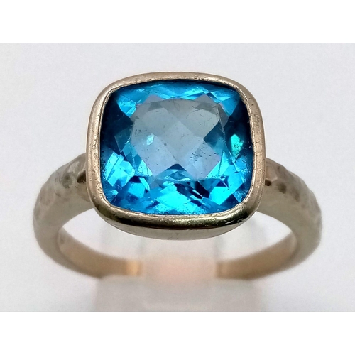 170 - A 9K White Gold Cushion-Cut Large Swiss-Blue Topaz Ring - Featuring Hammered Shoulders. Size U 1/2. ... 