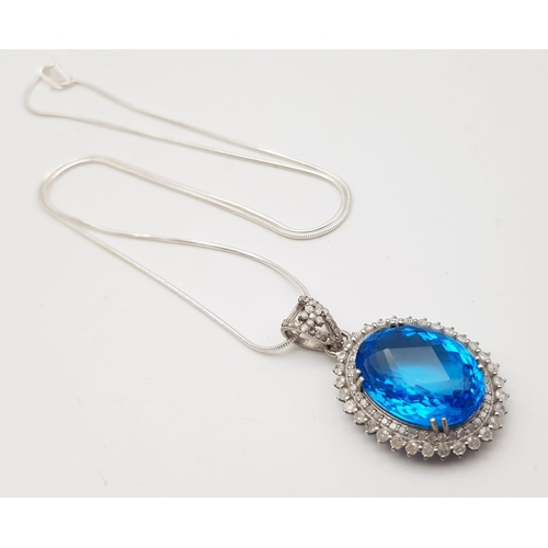 925 - A Well-Faceted Blue Topaz Pendant with a Halo of 2.5ct Diamonds approx. Topaz -20ct. Come  on a slim... 