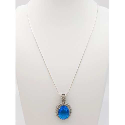 925 - A Well-Faceted Blue Topaz Pendant with a Halo of 2.5ct Diamonds approx. Topaz -20ct. Come  on a slim... 