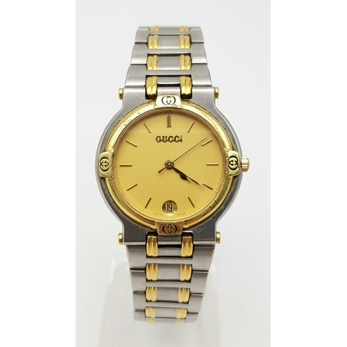 1030 - A Stylish Unisex Gucci Quartz Watch. Two tone stainless steel strap and case - 33mm. Gilded dial wit... 