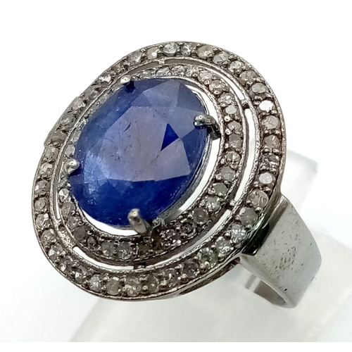 1073 - A 4.9ct Blue Oval Sapphire Gemstone Ring with .65ct of Diamonds in a Pave Setting. Size O. 4.95g tot... 