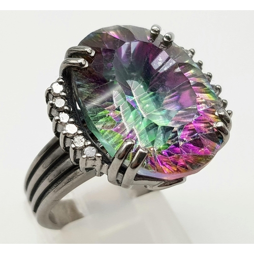 1164 - A 17.20ct Mystic Topaz Ring with .20ct Diamond accents. Set in 925 silver, black finish. Size N. 11g... 